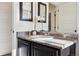 A sleek bathroom vanity featuring dark wood cabinetry, a light countertop, and stylish mirrors offers a blend of functionality and style at 1015 Auburn Dr, Erie, CO 80516