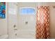The bright bathroom features a white tiled shower and tub with an eye-catching patterned shower curtain for a fresh, clean look at 1015 Auburn Dr, Erie, CO 80516