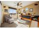 This charming bedroom features a unique design, a comfortable sitting area, and a playful ceiling fan for added character at 1015 Auburn Dr, Erie, CO 80516