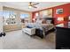 Spacious main bedroom features large windows, plush carpet, and a calming red accent wall at 1015 Auburn Dr, Erie, CO 80516