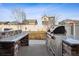 An outdoor kitchen boasts stone countertops and stainless steel features, perfect for hosting alfresco dining and grilling at 1015 Auburn Dr, Erie, CO 80516