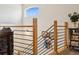 Modern staircase features sleek metal railings, warm wooden posts, and an eye-catching colorful art at 1015 Auburn Dr, Erie, CO 80516