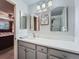 Bright bathroom with a gray vanity, dual mirrors, and a shower with a glass door at 4063 S Cathay Ct, Aurora, CO 80013