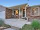 Charming home with brick accents, a welcoming front porch, and meticulously landscaped yard at 4063 S Cathay Ct, Aurora, CO 80013