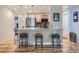 Open-concept kitchen with modern appliances, a breakfast bar with stools, and a view of the stainless steel refrigerator at 4063 S Cathay Ct, Aurora, CO 80013