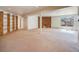 Large basement with sliding glass door, fireplace, and wooden shelving at 13640 W Center Dr, Lakewood, CO 80228