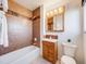 Bathroom featuring brown tile, vanity with mirror, and bathtub with shower combo at 13640 W Center Dr, Lakewood, CO 80228