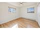 Bedroom featuring light hardwood floors, two windows, and white walls at 13640 W Center Dr, Lakewood, CO 80228