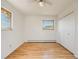 Bedroom featuring light hardwood floors, two windows, and white walls at 13640 W Center Dr, Lakewood, CO 80228