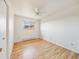 Bedroom with light hardwood floors and a window offering a pleasant neighborhood view at 13640 W Center Dr, Lakewood, CO 80228