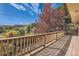 Spacious deck with wooden railing offering scenic views of the surrounding landscape at 13640 W Center Dr, Lakewood, CO 80228