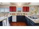 Well-lit kitchen showcasing stainless steel appliances, black cabinets, and access to an outdoor view at 13640 W Center Dr, Lakewood, CO 80228