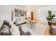 Well-lit living room featuring a large window, neutral decor, and comfortable furnishings at 13640 W Center Dr, Lakewood, CO 80228