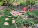 Inviting backyard featuring a cozy fire pit area, mature plants and landscaping, and a privacy fence at 6864 Balsam St, Arvada, CO 80004