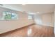 Unfurnished basement with hardwood floors, white walls, and natural light at 6864 Balsam St, Arvada, CO 80004