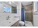 Stylish bathroom featuring tile shower, modern fixtures, and ample natural light from the window at 6864 Balsam St, Arvada, CO 80004