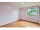 Bedroom featuring hardwood floors, light pink walls, and a large window at 6864 Balsam St, Arvada, CO 80004