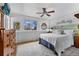 Cozy bedroom with wood accents, ceiling fan, and a large window offering natural light at 6864 Balsam St, Arvada, CO 80004