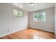 Bright bedroom featuring hardwood floors and natural light from two windows at 6864 Balsam St, Arvada, CO 80004