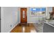 Bright foyer featuring hardwood floors, a beautiful front door, and a glimpse into the living area at 6864 Balsam St, Arvada, CO 80004