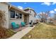 Charming home featuring a covered front porch with blue chairs, nice landscaping, and a neutral exterior at 6864 Balsam St, Arvada, CO 80004