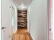 Hallway featuring hardwood floors and a decorative wood paneled wall between rooms at 6864 Balsam St, Arvada, CO 80004