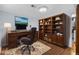 Office space with a desk, rolling chair, and large wooden bookshelf at 6864 Balsam St, Arvada, CO 80004
