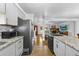 Updated kitchen featuring stainless steel appliances and granite countertops open to the living room at 6864 Balsam St, Arvada, CO 80004