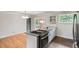 Modern kitchen island with gray cabinets, granite countertops, and stainless steel appliances, open to dining area at 6864 Balsam St, Arvada, CO 80004