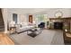 Staged living room with hardwood floors, a fireplace, and a large window that offers natural light at 6864 Balsam St, Arvada, CO 80004