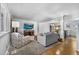 Cozy living room with hardwood floors, neutral colors, and a seamless transition to the dining area at 6864 Balsam St, Arvada, CO 80004