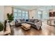 Bright living room with hardwood floors, a large sectional sofa, and abundant natural light at 11270 E 26Th Ave, Aurora, CO 80010