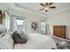 Bright main bedroom with ceiling fan, tray ceiling, and many windows at 11270 E 26Th Ave, Aurora, CO 80010