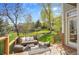 Relaxing back deck with outdoor seating, landscaped backyard, and mature trees for shade and privacy at 25 Summit Ash, Littleton, CO 80127