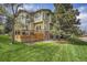 Backyard view of home's back deck and yard with mature trees at 25 Summit Ash, Littleton, CO 80127