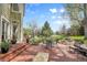 Charming backyard brick patio with elegant outdoor seating, a manicured lawn, and mature trees at 25 Summit Ash, Littleton, CO 80127