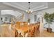 An open-concept dining room features hardwood floors, stylish chandelier, and easy access to stairs and living room at 25 Summit Ash, Littleton, CO 80127