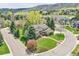 Well-manicured front yard of a home on a lovely tree-lined street with mountain views in the distance at 25 Summit Ash, Littleton, CO 80127