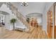 Spacious foyer features hardwood floors, grand staircase with iron railings and a view of the dining room beyond at 25 Summit Ash, Littleton, CO 80127