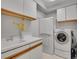 Functional laundry room with sink, white cabinets, and modern washer and dryer at 25 Summit Ash, Littleton, CO 80127