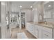 Bright main bathroom featuring double vanity, freestanding tub, and white cabinetry with granite countertops at 25 Summit Ash, Littleton, CO 80127