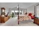 Serene main bedroom with four-poster bed, plush carpet, and abundant natural light from surrounding windows at 25 Summit Ash, Littleton, CO 80127