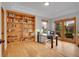 Well-lit office space with custom built-in shelves, hardwood floors, and access to outdoor space at 25 Summit Ash, Littleton, CO 80127
