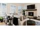 Cozy living room with a stone fireplace, plush seating, and natural light from shuttered windows at 22065 E Bailey Pl, Aurora, CO 80016