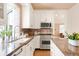 Bright, updated kitchen with stainless steel appliances, granite countertops, and white cabinetry at 1220 S Vine St, Denver, CO 80210