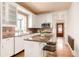 Charming updated kitchen with white cabinetry, tile backsplash, and a kitchen island with bar seating at 1220 S Vine St, Denver, CO 80210