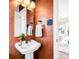 Charming powder room with unique textured walls and a decorative mirror and sink at 1220 S Vine St, Denver, CO 80210