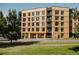Modern condo building with wood paneled siding and black accents, set against a blue sky at 1601 Park Ave # 214, Denver, CO 80218