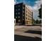 Modern condo building showcasing a mix of black and wood paneled exterior on a sunny day at 1601 Park Ave # 214, Denver, CO 80218