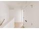 Bright hallway featuring white walls, light wood floors, and modern doors with black hardware at 1601 Park Ave # 214, Denver, CO 80218